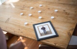 A framed memorial photo surrounded by candles on a wooden table, symbolizing remembrance and grief on Father's Day.